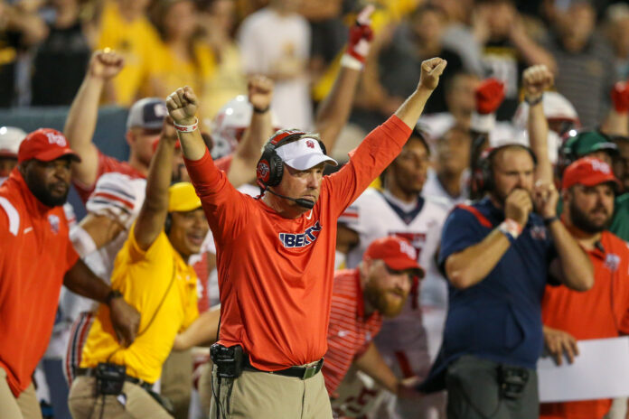 Hugh Freeze Hugh Freeze raises hands in celebration during a Liberty football game